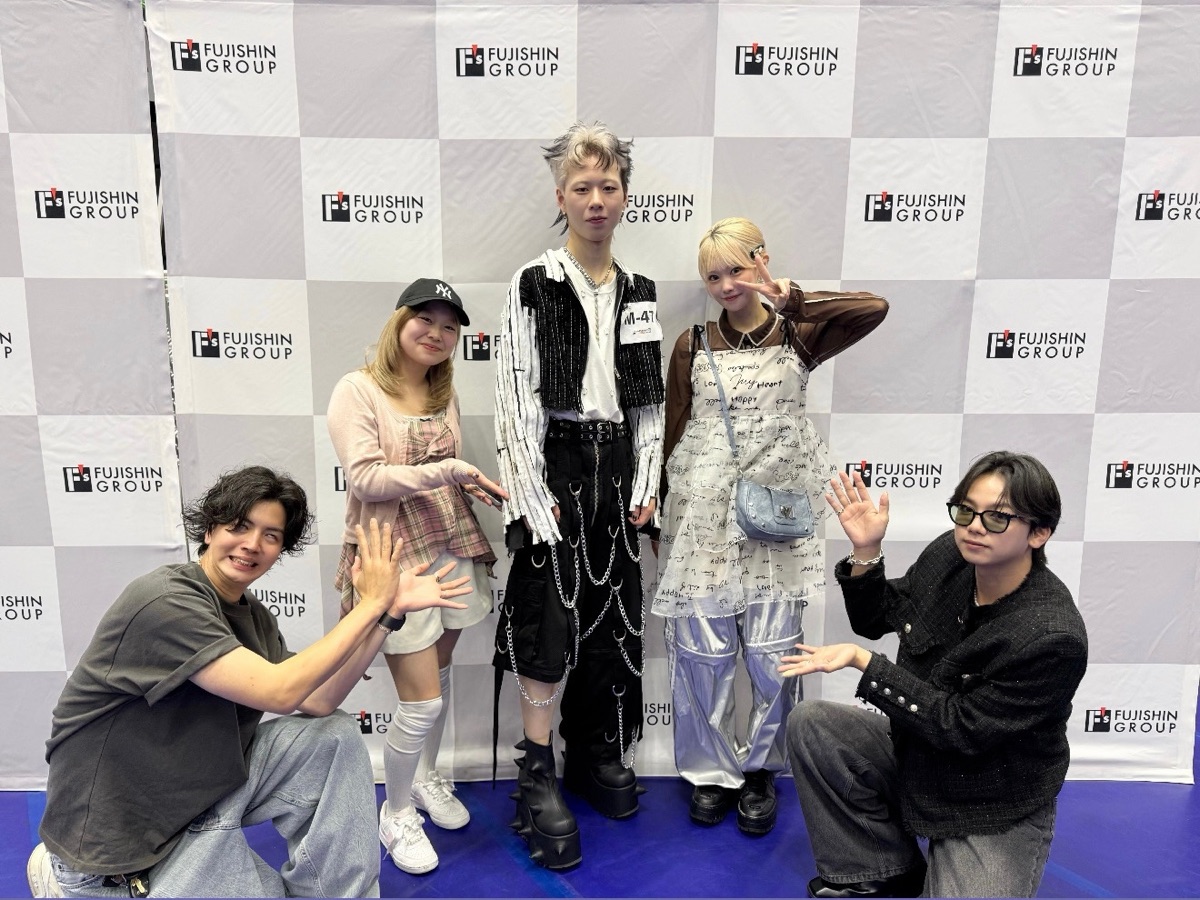 大会終了後、バックパネルの前で記念撮影をする MARIA・大菅翼と応援に駆けつけたスタッフ