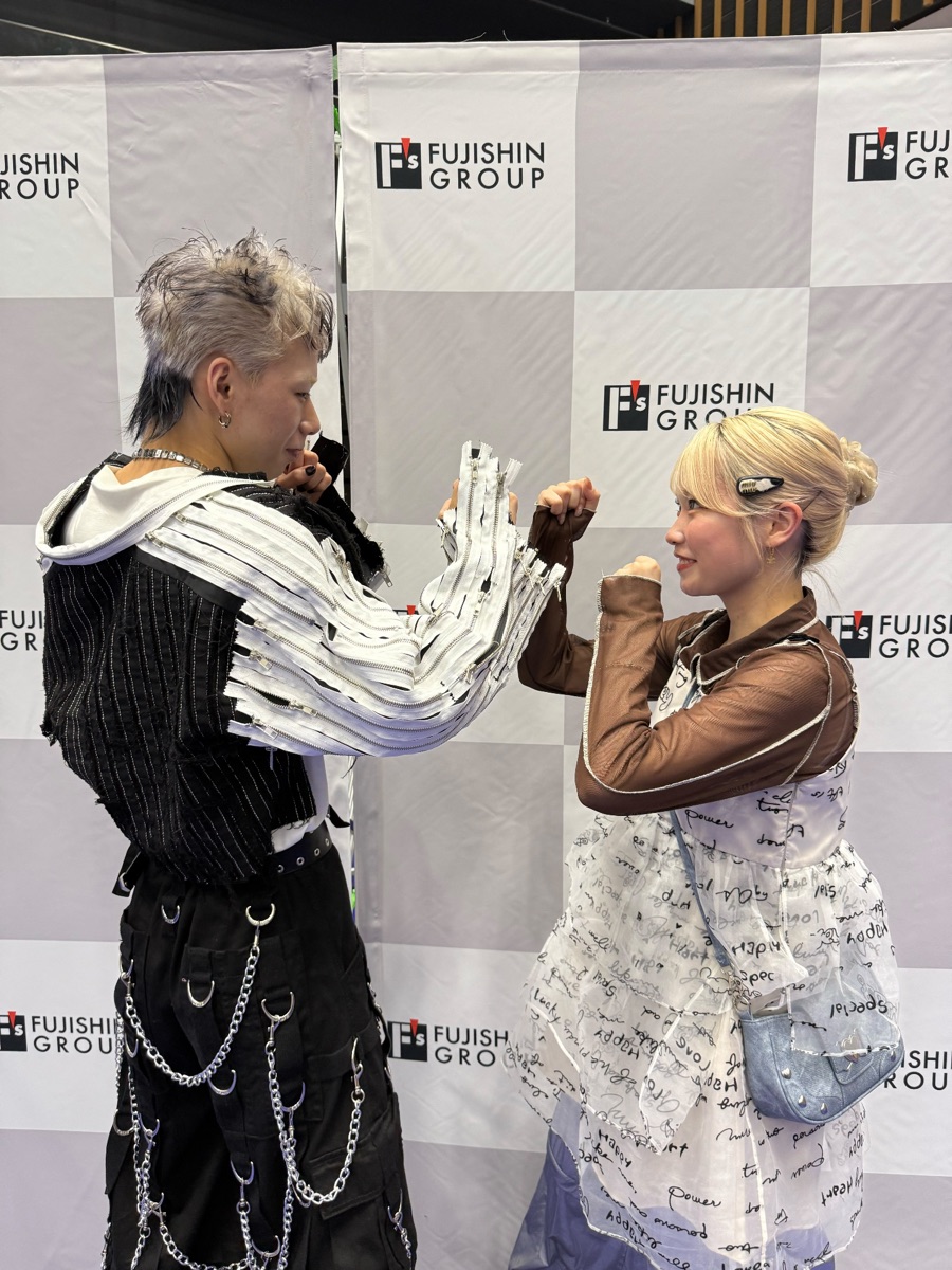 向き合ってポーズを取る MARIA と、モデルを務めたスタッフの大菅翼